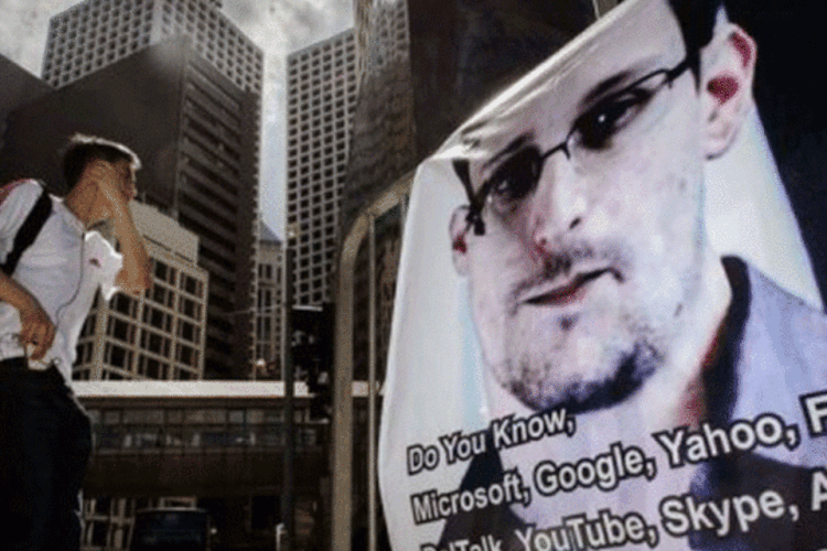 
	Cartaz com a foto de Edward Snowden em Hong Kong: &quot;Snowden solicitou asilo a outros seis pa&iacute;ses. N&atilde;o ser&atilde;o desvelados por enquanto devido &agrave; interfer&ecirc;ncia dos Estados Unidos&quot;, diz WikiLeaks
 (Philippe Lopez/AFP)