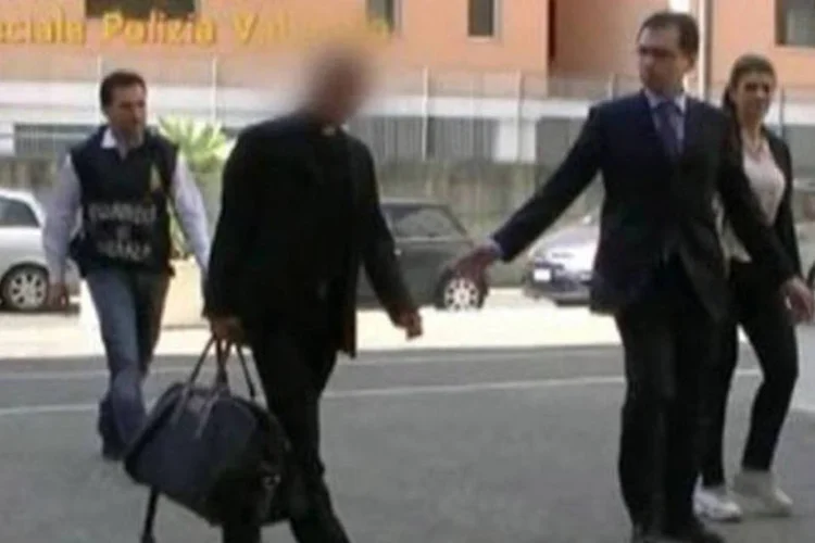 
	Scarano &eacute; escoltado por policiais: ele foi preso na semana passada na companhia de Giovanni Zito, agente do servi&ccedil;o secreto, e do operador financeiro Giovanni Carenzio
 (AFP)