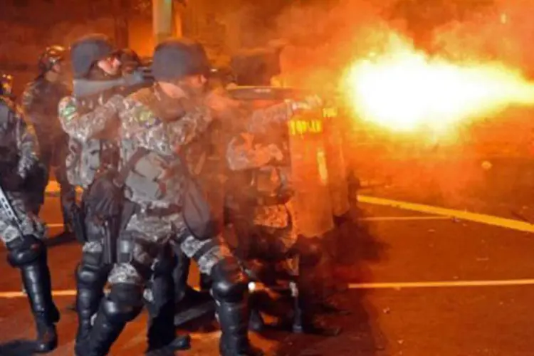 Polícia tenta conter manifestantes nos arredores do Maracanã, durante a final da Copa das Confederações: de um lado, uma chuva de gols e a torcida em festa. Do outro, a fumaça e o cheiro de gás em protestos que levam milhares às ruas com uma forte repressão policial (Tasso Marcelo/AFP)