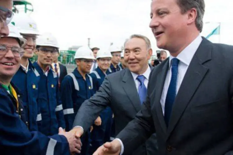 
	Primeiro-ministro brit&acirc;nico, David Cameron (d), se encontra com trababalhadores de uma ind&uacute;stria petrol&iacute;fera: Cameron se comprometeu a renegociar os termos da rela&ccedil;&atilde;o do pa&iacute;s com a UE
 (Leon Neal/AFP)