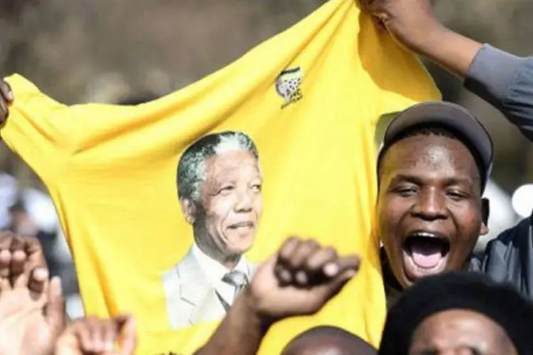 Pessoas celebram o aniversário do ex-presidente da África do Sul Nelson Mandela: muitas ações beneficentes ou simbólicas serão realizadas para celebrar o dia 18 de julho, estabelecido pela ONU como o "Mandela Day" (Stephane de SakutinAFP)