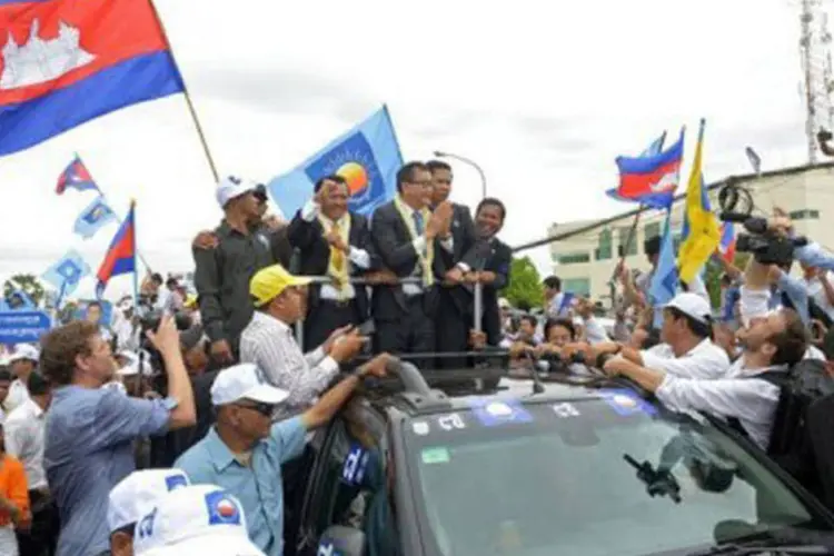 
	L&iacute;der da oposi&ccedil;&atilde;o do Camboja, Sam Rainsy, cumprimenta simpatizantes: Rainsy havia fugido do Camboja em 2009 para escapar de tr&ecirc;s condena&ccedil;&otilde;es &agrave; pris&atilde;o que somavam 11 anos
 (Tang Chhin Sothy/AFP)