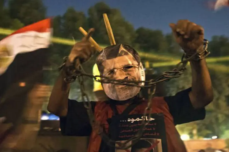 Homem usa máscara do presidente deposto do Egito, Mohamed Mursi, em protestos no Cairo nesta sexta-feira (19) (Khaled Desouki/AFP)