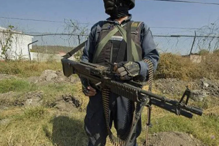
	Policial mexicano monta guarda em Apatzingan, no estado de Michoac&aacute;n: ataques come&ccedil;aram quando homens armados com rifles de alto poder de fogo atacaram policiais em regi&atilde;o tensa do pa&iacute;s
 (Alfredo Estrella/AFP)