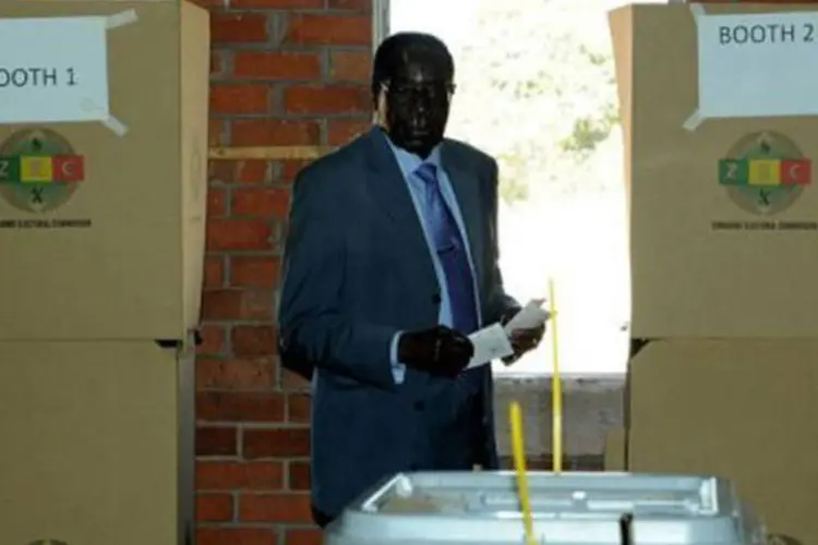 O presidente do Zimbábue, Robert Mugabe, prestes a depositar seu voto em uma seção eleitoral: no passado, Mugabe foi escolhido em eleições marcadas por fraude e violência (Alexander Joe/AFP)