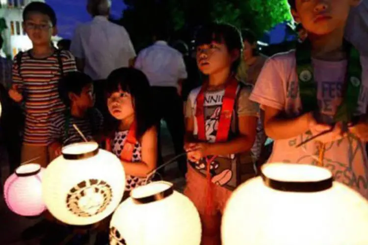 Crianças carregam lanternas em homenagem aos mortos de Hiroshima nesta segunda-feira (5) (Toru Yamanaka/Reuters)