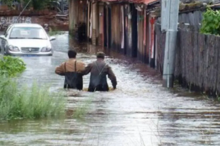 
	Moradores caminham por &aacute;rea inundada de Yakeshi, na regi&atilde;o da Mong&oacute;lia, em 25 de julho: o governo mobilizou 2.800 soldados para as tarefas de resgate
 (AFP)