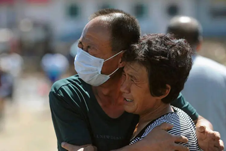 
	Pessoas que perderam seus parentes na enchente se abra&ccedil;am na prov&iacute;ncia de Liaoning, na China: mais de 500 mil pessoas foram evacuadas nas regi&otilde;es mais castigadas
 (China Daily/Reuters)