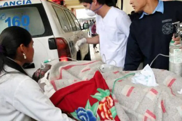 Médicos socorrem mulher ferida na prisão de Palmasola em Santa Cruz, Bolívia, nesta sexta-feira (23) (AFP)