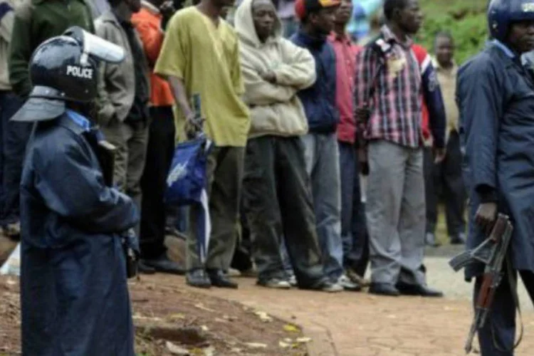 
	Policiais armados quenianos mant&ecirc;m curiosos longe do lado de fora do shopping Westgate em Nair&oacute;bi: se completam 48 horas do in&iacute;cio do ataque dos fundamentalistas
 (Simon Maina/AFP)
