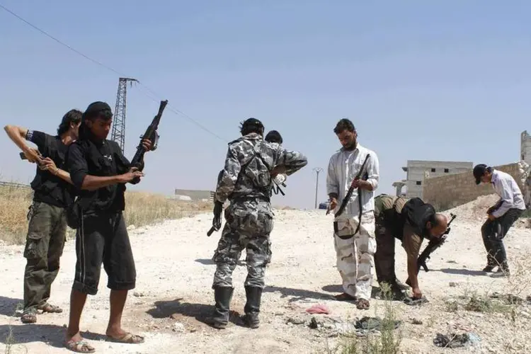 Soldados do Exército Livre Sírio com suas armas: "o regime transfere civis detidos sem julgamento a lugares que poderiam ser alvo de combates" disse oposição (Molhem Barakat/Reuters)