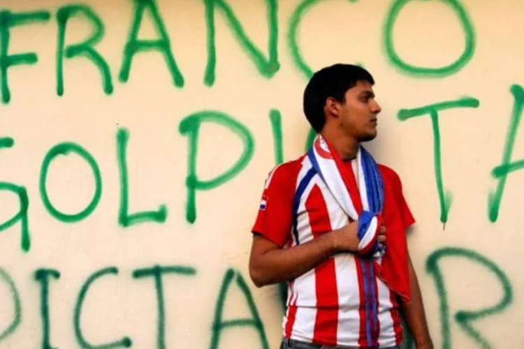 Pessoa na frente de uma pichação que chama o vice-presidente paraguaio Franco de "golpista" (Jorge Adorno/Reuters)
