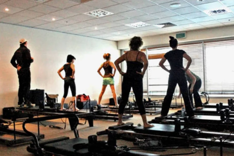 
	Pessoas praticam pilates em uma academia: a pr&aacute;tica tem sido uma das mais indicadas pelos m&eacute;dicos no tratamento de diversas patologias
 (Wikimedia Commons)