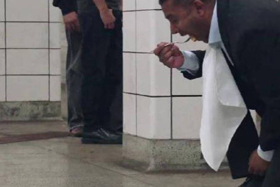 Homem come no chão da estação para mostrar produto