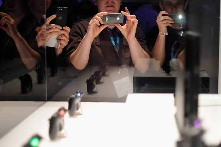 
	Pessoas tiram foto do PlayStation 4 em evento de lan&ccedil;amento do console: Em um fundo de renda fixa, pre&ccedil;o do videogame renderia 877 reais
 (Kevork Djansezian/Getty Images)