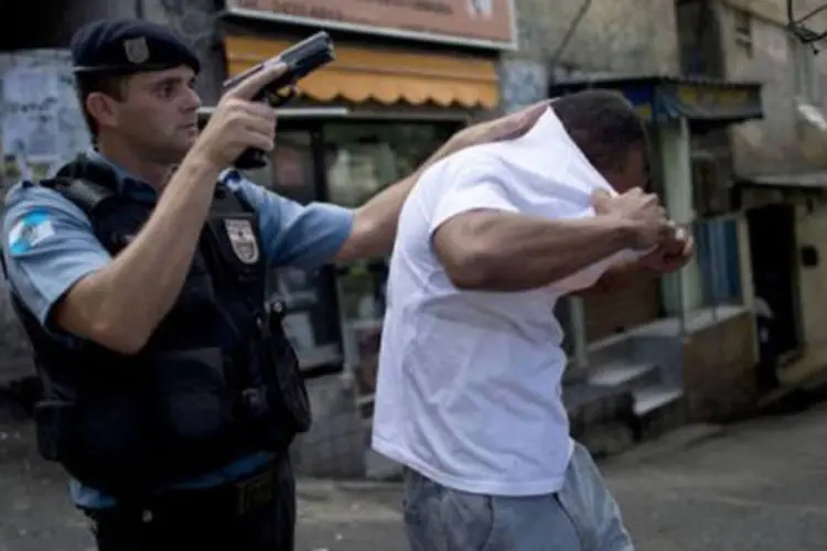 Policial Militar prende suspeito de matar PM na favela da Rocinha: hoje em dia, mais de 5.500 policiais atuam nas 25 UPPs que controlam 140 das 750 favelas do Rio de Janeiro (©AFP / Christophe Simon)