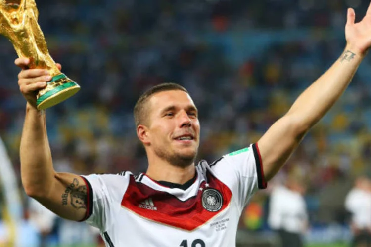 Podolski levanta o troféu da Copa do Mundo 2014 após a Alemanha vencer a Argentina por 1x0 na prorrogação e se tornar tetracampeã (Julian Finney/Getty Images)