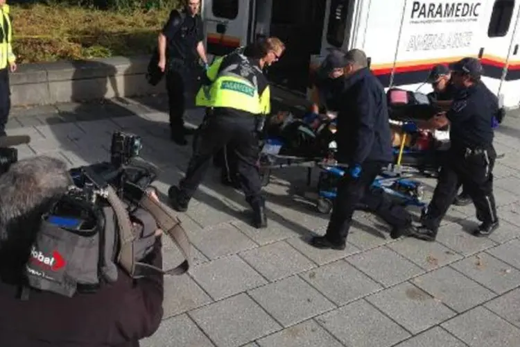 
	Pol&iacute;cia e equipes m&eacute;dicas removem uma pessoa ferida no parlamento do Canad&aacute;
 (Michel Comte/AFP)