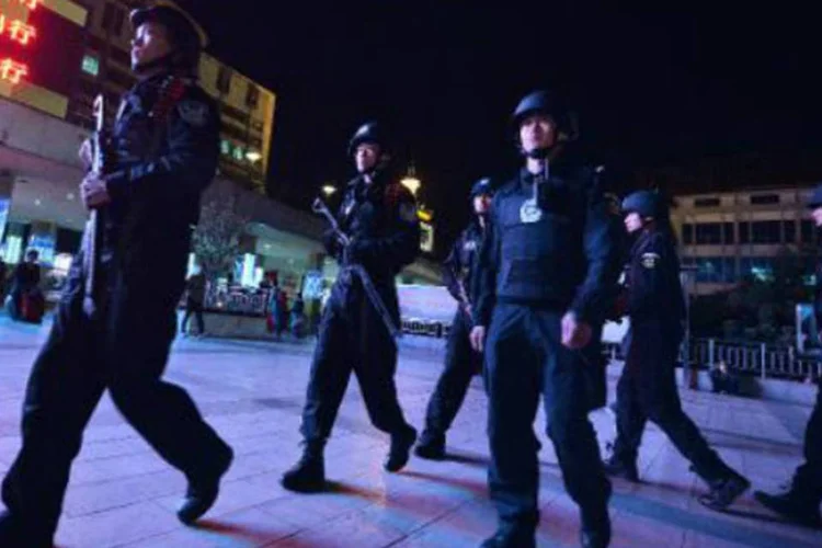 Polícia chinesa patrulha cena do crime na estação de trem de Kunming: governo chinês culpa o atentado a um bando terrorista (Mark Ralston/AFP)