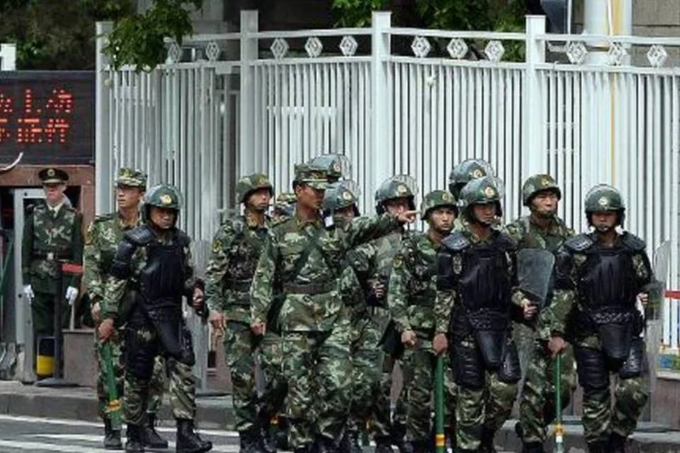 Polícia militar faz uma patrulha nas ruas de Urumqi, capital de Xinjiang, após um atentado (Goh Chai Hin/AFP)