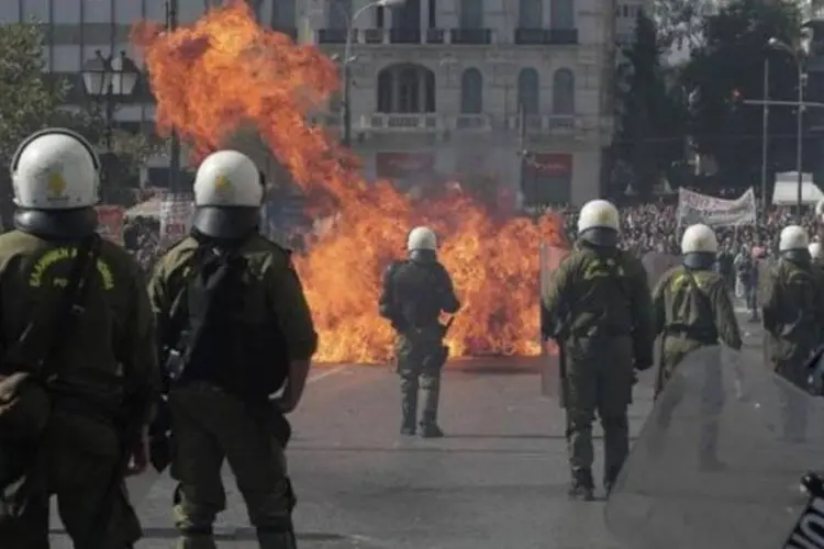 Manifestantes atiram coquetel molotov em direção a policiais no centro de Atenas, na Grécia (Costas Baltas/Reuters)