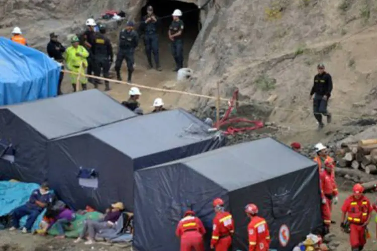 Polícia faz guarda na entrada de mina Cabeça de Negro, no sul do Peru, e equipe de resgate se prepara para a ação nesta quarta-feira (Cris Bouroncle/AFP)