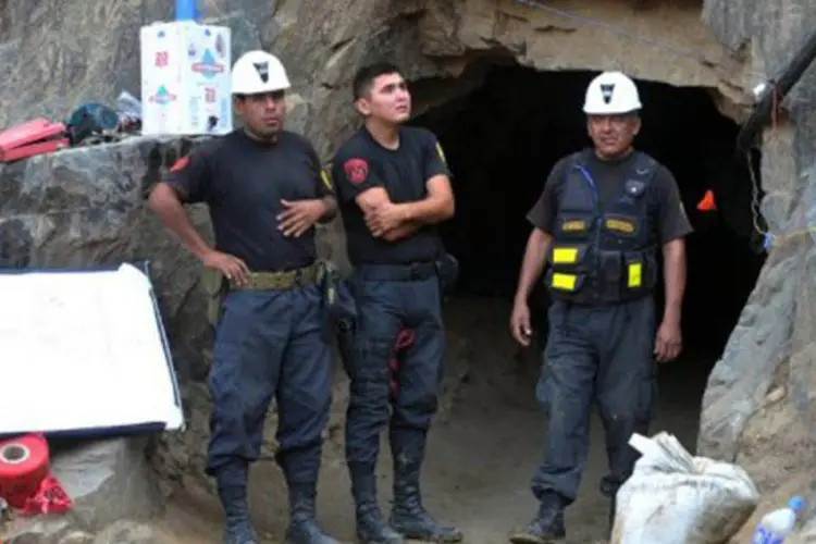 Polícia faz guarda na entrada de mina Cabeça de Negro, no sul do Peru: os trabalhadores não estão feridos e recebem oxigênio e bebidas por meio de um tubo
 (Cris Bouroncle/AFP)