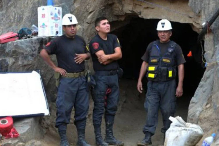 Polícia faz guarda na entrada de mina Cabeça de Negro, no sul do Peru: os trabalhadores não estão feridos e recebem oxigênio e bebidas por meio de um tubo (Cris Bouroncle/AFP)