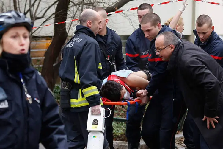 
	Bombeiros carregam v&iacute;tima ap&oacute;s tiroteio no escrit&oacute;rio do jornal sat&iacute;rico Charlie Hebdo: o ataque deixou mais de 20 feridos
 (REUTERS/Jacky Naegelen)