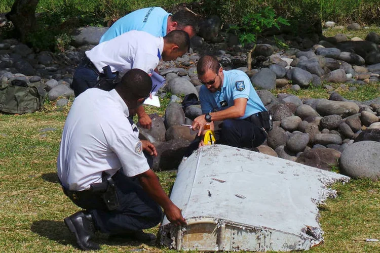
	Pol&iacute;cia francesa inspeciona o peda&ccedil;o de avi&atilde;o encontrado na praia de Saint-Andre
 (Reuters/ Prisca Bigot)