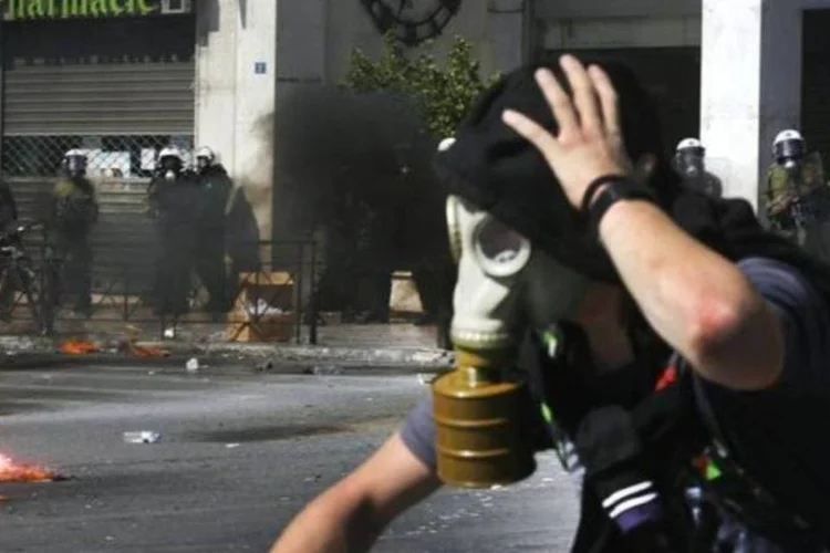 Manifestante é visto fugindo da polícia em Atenas, na Grécia (Yannis Behrakis/Reuters)