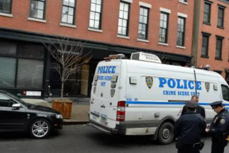 Agentes da polícia de Nova York vigiam entrada do edifício onde vivia o ator Philip Seymor Hoffman: morte foi aparentemente por overdose (Stan Honda/AFP)