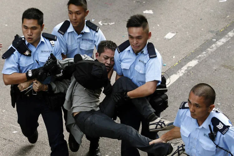 Polícia de Hong Kong leva detido manifestante: área pujante perto do porto tem sido o cenário de alguns dos confrontos mais violentos (Bobby Yip/Reuters)