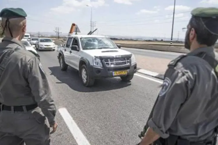 Policiais israelenses monitoram carros em estrada nos arredores de Kfar Yona (Jack Guez/AFP)