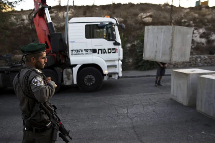 
	Bloqueio de concreto sendo constru&iacute;do em Jerusal&eacute;m: entre outras a&ccedil;&otilde;es os corpos dos palestinos autores de ataques abatidos pelas for&ccedil;as de seguran&ccedil;a n&atilde;o ser&atilde;o entregues as suas fam&iacute;lias
 (Reuters / Ronen Zvulun)