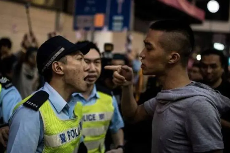 Policial discute com homem que atacou manifestantes pró-democracia em Hong Kong (Alex Ogle/AFP)