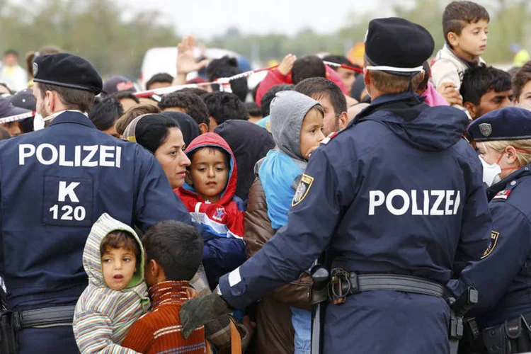 
	Pol&iacute;cia mant&eacute;m ordem entre refugiados na cidade de Nickelsdorf, na fronteira da Austria com a Alemanha: &eacute; na separa&ccedil;&atilde;o entre os pa&iacute;ses que s&atilde;o feitos os registros de impress&otilde;es digitais dos que pedem ref&uacute;gio
 (Reuters / Leonhard Foeger/Reuters)