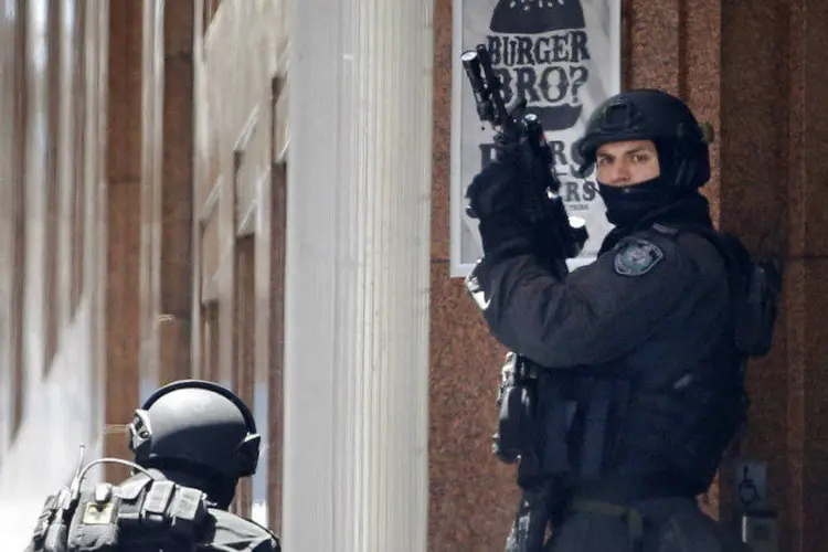 Policiais se posicionam perto do café onde homem mantém reféns em Sydney, Austrália (Jason Reed/Reuters)