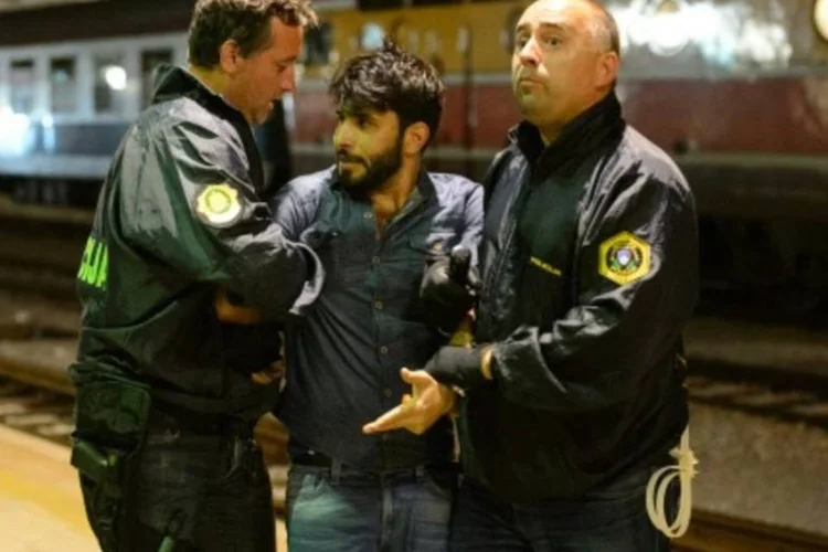 Policiais prendem migrante que tentou embarcar em um trem na estação próxima a fronteira com a Croácia, em Dobova (Jure Makovec/AFP)