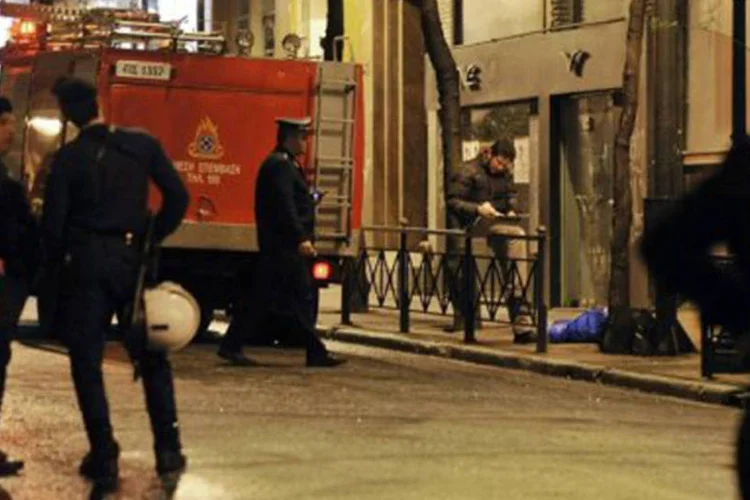 Policiais e bombeiros trabalham do lado de fora de escritório de ex-premiê (©AFP / Louisa Gouliamaki)