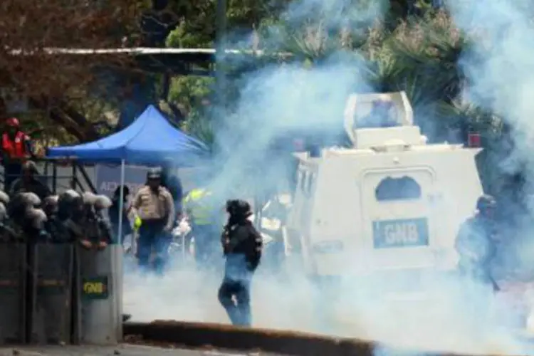 Policiais da Guarda Nacional venezuelana en protesto opositor: estudantes jogaram pedras, e a polícia respondeu com gás lacrimogêneo e jatos d'água (AFP)