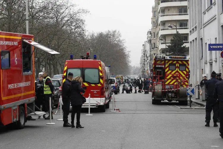 Policiais investigam tiroteio na sede da revista francesa Charlie Hebdo, em Paris, na França, nesta quarta-feira (Youssef Boudlal/Reuters)