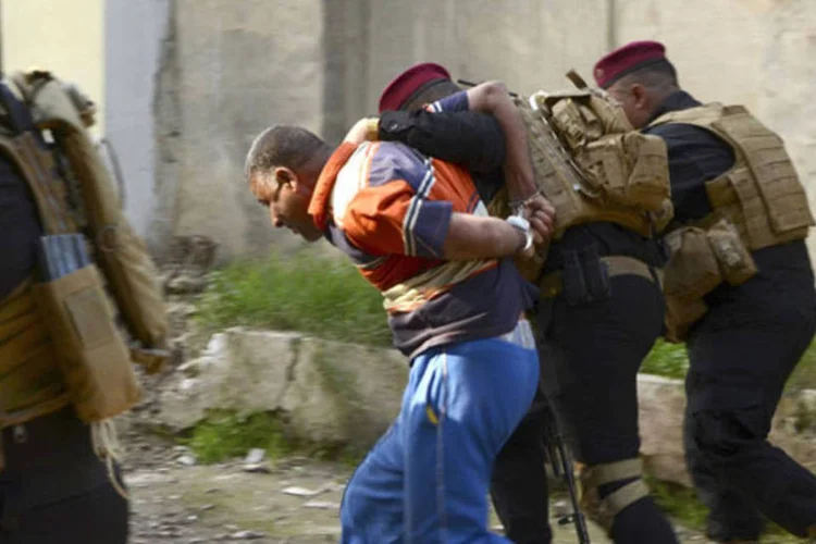 Membros da Força de Operações Especiais do Iraque prendem um militante suspeito durante uma operação no distrito de Abu Ghraib, oeste de Bagdá (Reuters)