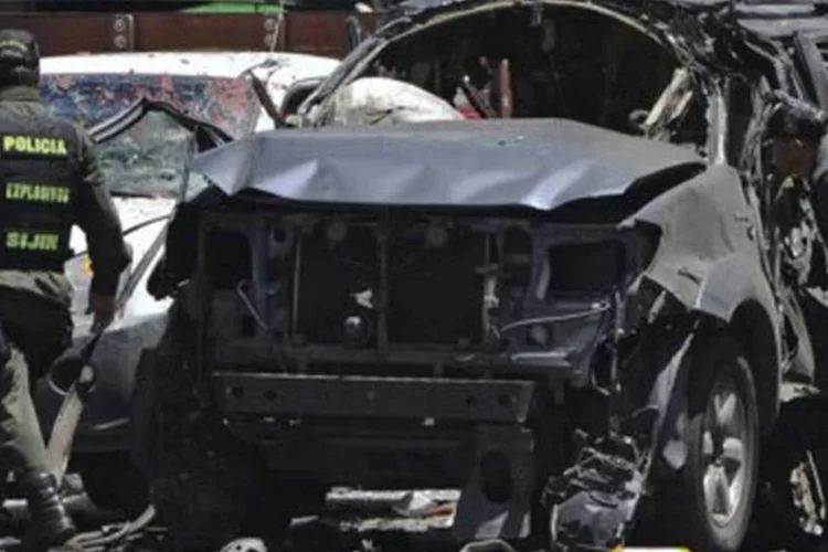 Policiais observam escombros de carro de ex-ministro colombiano após atentado em Bogotá (©AFP / guillermo legaria)