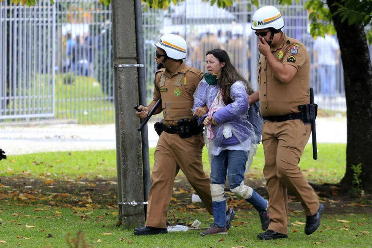 Policiais levam professora durante confronto no Centro Cívico em Curitiba (Agência Paraná/Fotos Públicas)