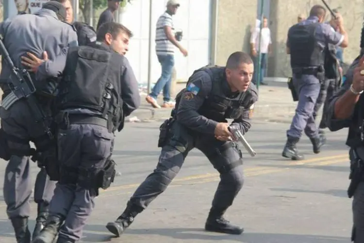 Policiais militares entram em confronto com manifestantes e reagem sacando armas durante reintegração de posse no Rio de Janeiro (Vladimir Platonow/ABr)