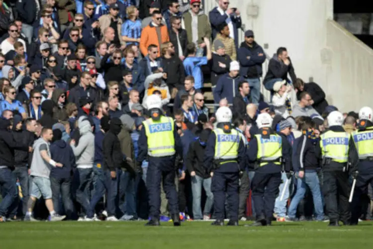 Policiais tentam controlar invasão de campo durante jogo na Suécia: torcedores invadiram o campo aos gritos de "assassinos" depois de saberem da tragédia (Bjorn Lindgren/TT News Agency/Reuters)