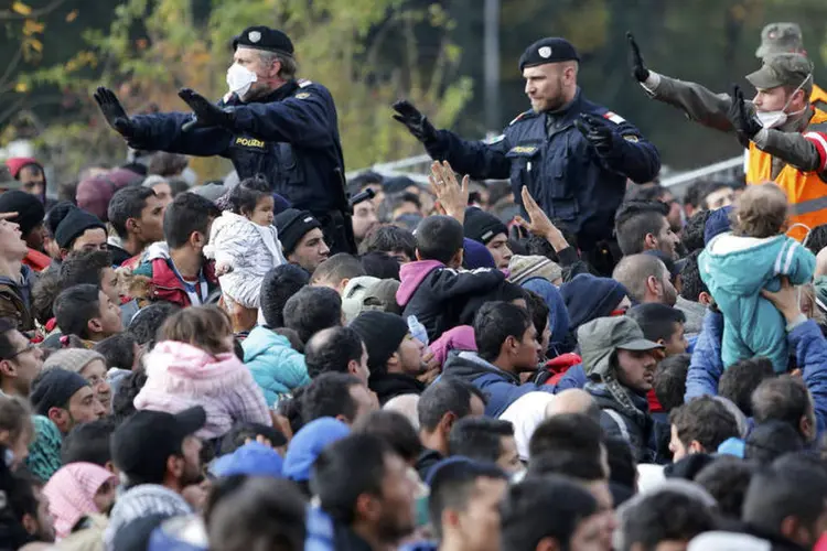 
	Policiais tentam controlar multid&atilde;o de refugiados na fronteira da &Aacute;ustria
 (Reuters / Srdjan Zivulovic)