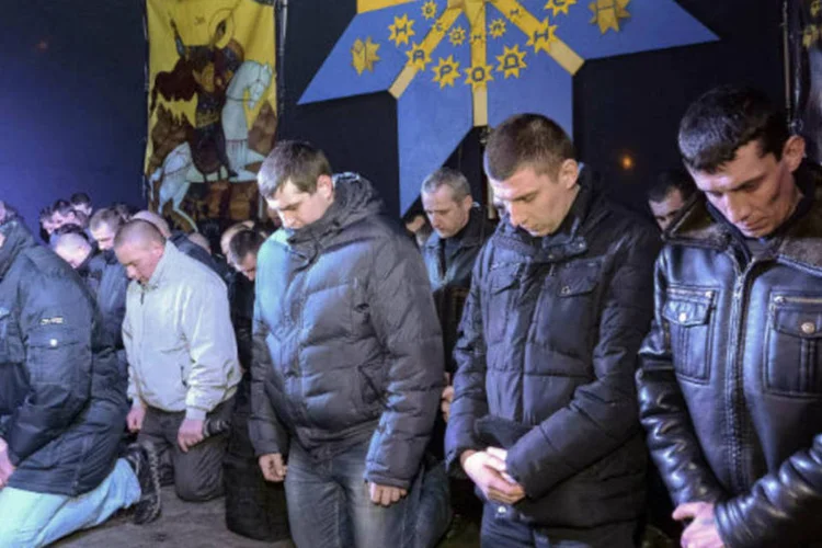 Policiais de joelhos pedem perdão em Lviv, na Ucrânia: ato público de desculpas aconteceu ontem à noite (Roman Baluk/Reuters)