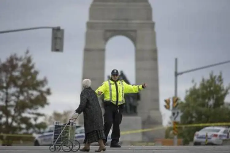 Policial instrui senhora perto de monumento no Canadá (Peter McCabe/AFP)